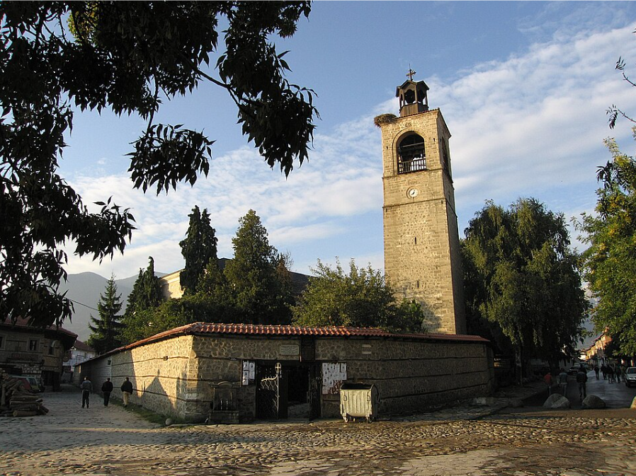 Павославна църква с висока камбанария и кръст.
