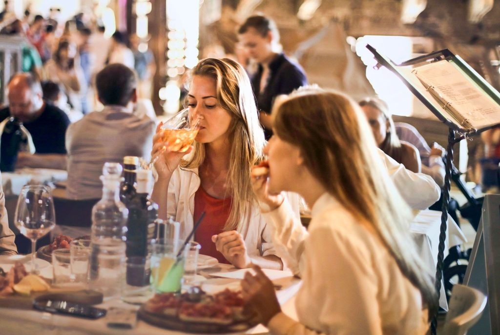 Чомлек: вкусът на Банско в едно гърне Две жени се хранят и пият напитки на маса в заведение.